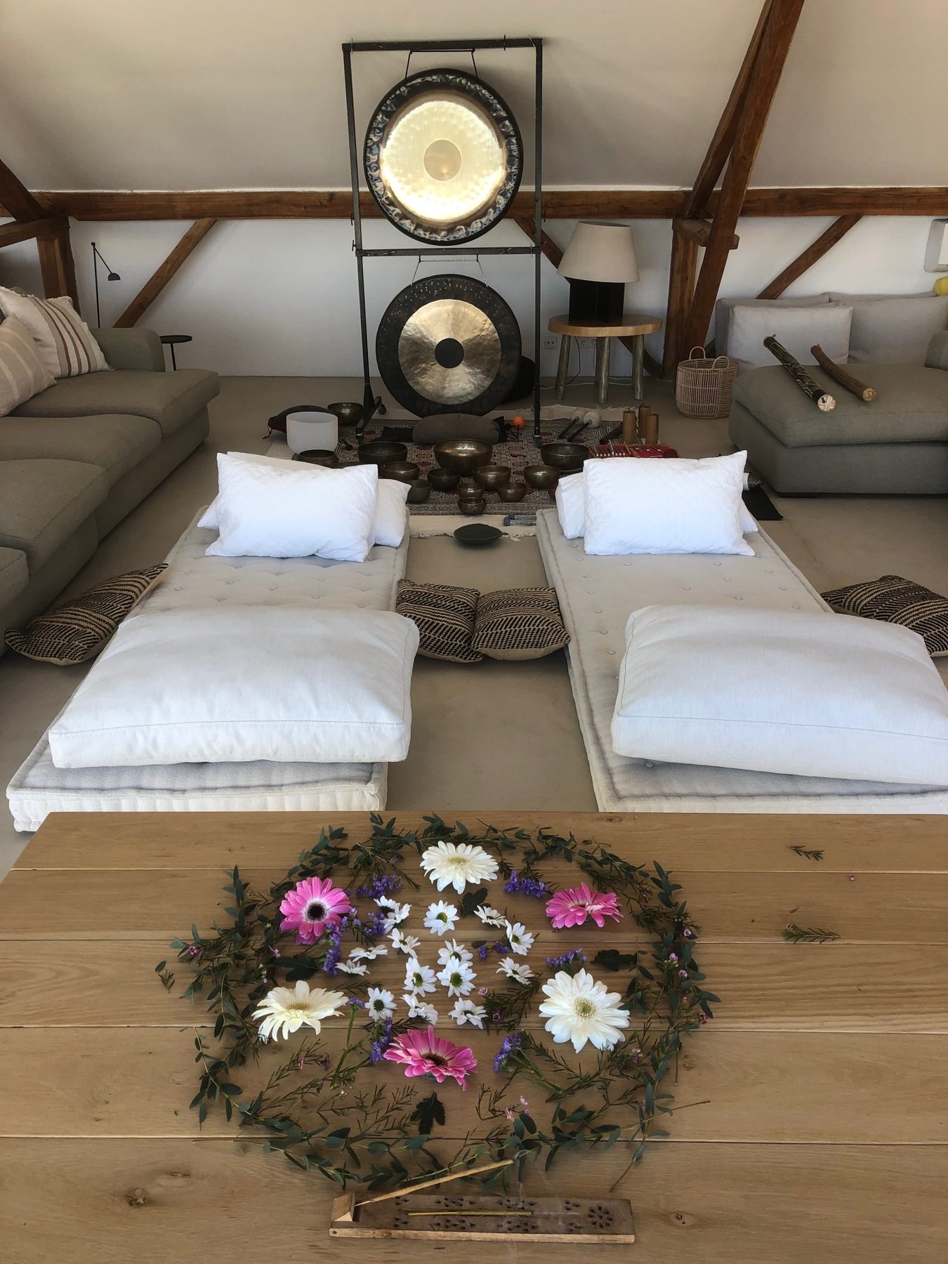 Two mattresses facing gongs with a flower mandala